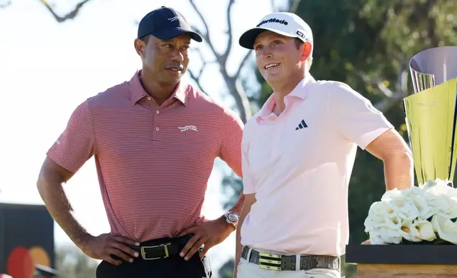 Jacob Bridgeman, right, stands with Tiger Woods after winning the Genesis Invitational golf tournament at Riviera Country Club, Sunday, Feb. 22, 2026, in the Pacific Palisades area of Los Angeles. (AP Photo/Caroline Brehman )