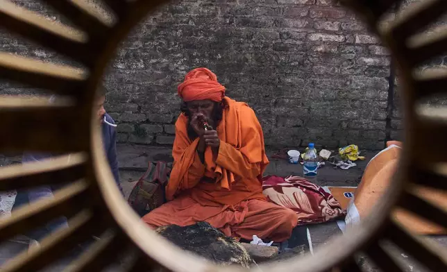 A holy man smokes marijuana during Maha Shivaratri festival at the Pashupatinath temple premises in Kathmandu, Nepal, Sunday, Feb. 15, 2026. (AP Photo/Niranjan Shrestha)
