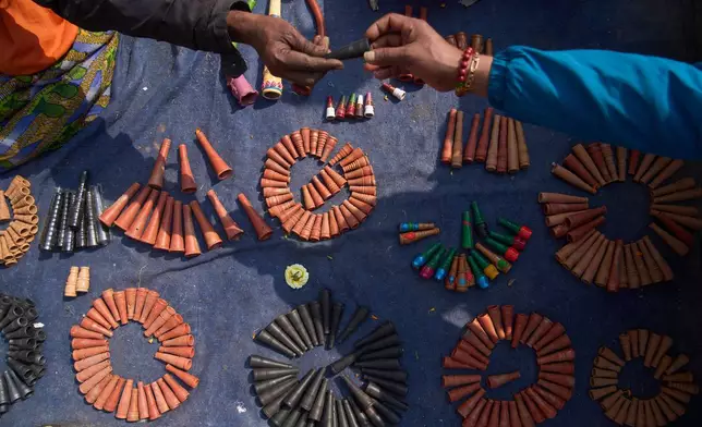 A man displays smoking pot to sell to devotees during Maha Shivaratri festival at the Pashupatinath temple premises in Kathmandu, Nepal, Sunday, Feb. 15, 2026. (AP Photo/Niranjan Shrestha)