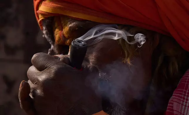 A holy man smokes marijuana during Maha Shivaratri festival at the Pashupatinath temple premises in Kathmandu, Nepal, Sunday, Feb. 15, 2026. (AP Photo/Niranjan Shrestha)