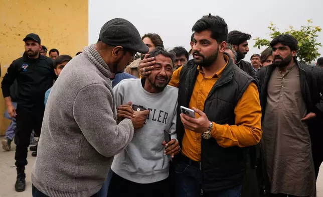 People comfort a man, center, mourning over the death of his relative, close to the site of a bomb explosion at a Shiite mosque, in Islamabad, Pakistan, Friday, Feb. 6, 2026. (AP Photo/Anjum Naveed)