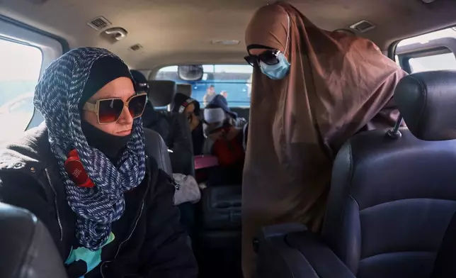 Family members of suspected Islamic State militants who are Australian nationals board a van heading to the airport in Damascus during the first repatriation operation of the year, at Roj Camp in eastern Syria, Monday, Feb. 16, 2026. Thirty-four Australian citizens from 11 families departed the camp. (AP Photo/Baderkhan Ahmad)