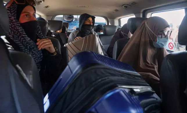 Family members of suspected Islamic State militants who are Australian nationals sit in a van heading to the airport in Damascus during the first repatriation operation of the year, at Roj Camp in eastern Syria, Monday, Feb. 16, 2026. Thirty-four Australian citizens from 11 families departed the camp. (AP Photo/Baderkhan Ahmad)