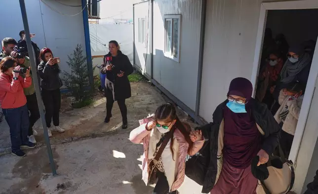Family members of suspected Islamic State militants who are Australian nationals walk toward a van bound for the airport in Damascus during the first repatriation operation of the year at Roj Camp in eastern Syria, Monday, Feb. 16, 2026. Thirty-four Australian citizens from 11 families departed the camp. (AP Photo/Baderkhan Ahmad)