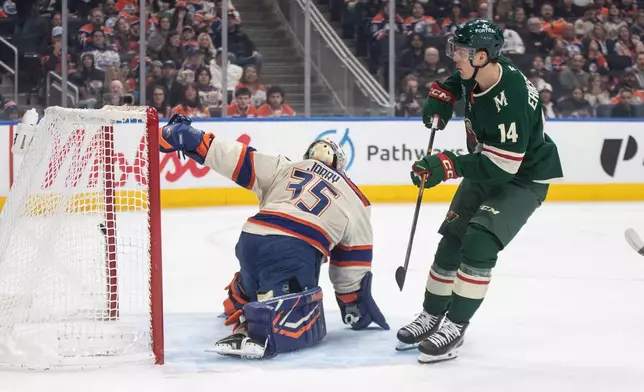 Minnesota Wild's Joel Eriksson Ek (14) scores against Edmonton Oilers goalie Tristan Jarry (35) during first-period NHL hockey game action in Edmonton, Alberta, Saturday, Jan. 31, 2026. (Jason Franson/The Canadian Press via AP)