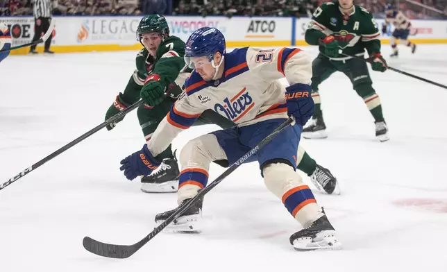 Minnesota Wild's Brock Faber (7) tries to stop Edmonton Oilers' Curtis Lazar (20) during second period NHL action, in Edmonton on Saturday, Jan. 31, 2026. (Jason Franson/The Canadian Press via AP)