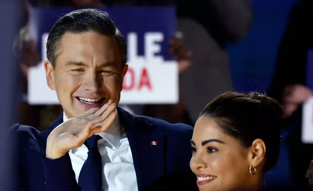 Conservative Party Leader Pierre Poilievre, and wife Anaida arrive at the podium as he prepares to deliver his keynote address at the party's national convention in Calgary, Friday, Jan. 30, 2026. (Larry MacDougal /The Canadian Press via AP)