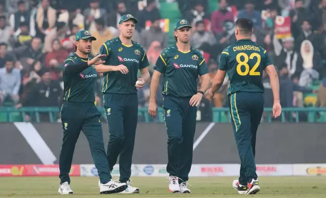 Australia's Ben Dwarshuis, right, celebrates with teammates after the dismissal of Pakistan's Salman Ali Agha during the third T20 cricket match between Pakistan and Australia, in Lahore, Pakistan, Sunday, Feb. 1, 2026. (AP Photo/K.M. Chaudary)