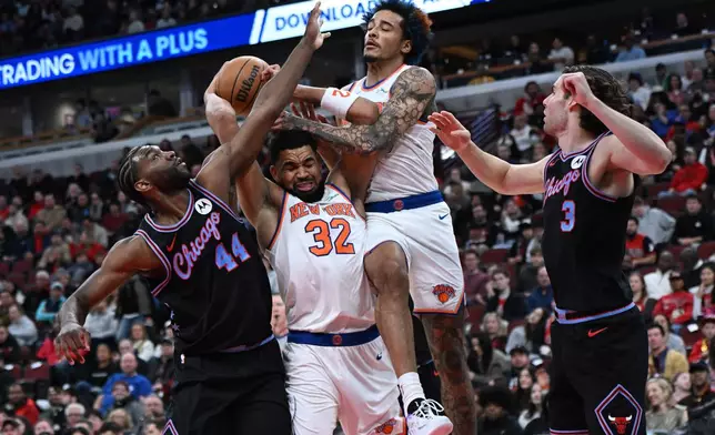 New York Knicks' Karl-Anthony Towns (32) and Jeremy Sochan, second from right, battle for a rebound against Chicago Bulls' Patrick Williams (44) and Josh Giddy (3) during the first half of an NBA basketball game Sunday, Feb. 22, 2026, in Chicago. (AP Photo/Paul Beaty)