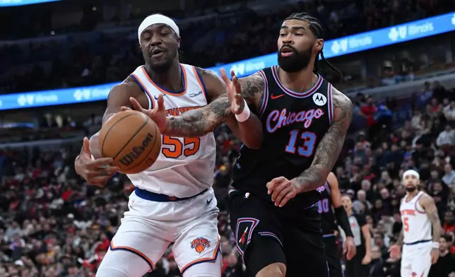 New York Knicks' Ariel Hukporti (55) battles Chicago Bulls' Nick Richards (13) for a loose ball during the first half of an NBA basketball game, Sunday, Feb. 22, 2026, in Chicago. (AP Photo/Paul Beaty)