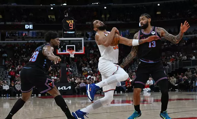 New York Knicks' Karl-Anthony Towns, center, drives against Chicago Bulls' Nick Richards (13) and Guerschon Yabusele (28) during the first half of an NBA basketball game Sunday, Feb. 22, 2026, in Chicago. (AP Photo/Paul Beaty)