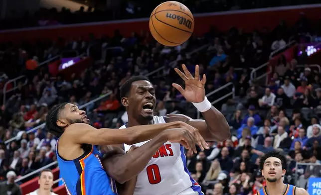 Oklahoma City Thunder guard Isaiah Joe fouls Detroit Pistons center Jalen Duren (0) while going to the basket during the first half of an NBA basketball game, Wednesday, Feb. 25, 2026, in Detroit. (AP Photo/Duane Burleson)