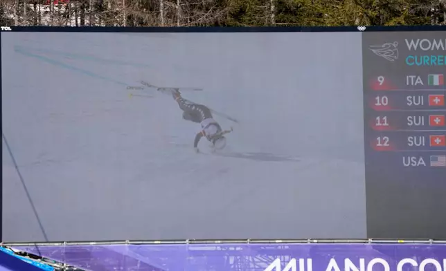 United States' Lindsey Vonn's crash is seen on a giant screen at the finish area of an alpine ski women's downhill race, at the 2026 Winter Olympics, in Cortina d'Ampezzo, Italy, Sunday, Feb. 8, 2026. (AP Photo/Andy Wong)