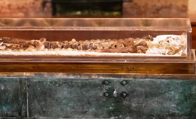 The remains of Francis of Assisi are displayed in a glass case inside the Basilica of St. Francis of Assisi in Assisi, Italy, Saturday, Feb. 21, 2026, on the eve of a public exposition beginning Feb. 22 to mark the 800th anniversary of his death in 1226. (AP Photo/Gregorio Borgia)