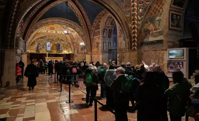 Pilgrims honor the bones of St. Francis during the first public display inside the St. Francis Basilica, marking the 800th anniversary of the saint death, in Assisi, Italy, Sunday, Feb. 22, 2026.(AP Photo/Gregorio Borgia)