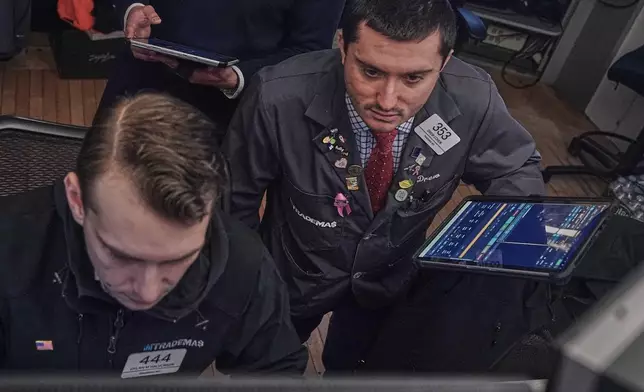 Traders Dylan Halvorsan, left, and Drew Cohen work on the floor of the New York Stock Exchange, Friday, Feb. 13, 2026, in New York. (AP Photo/Richard Drew)