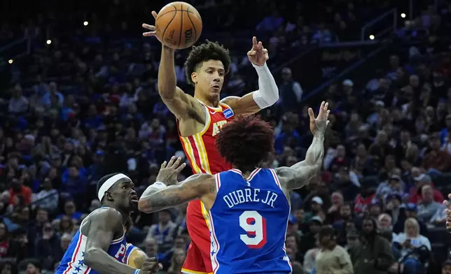 Atlanta Hawks' Jalen Johnson passes past Philadelphia 76ers' Kelly Oubre Jr. during the first half of an NBA basketball game Thursday, Feb. 19, 2026, in Philadelphia. (AP Photo/Matt Rourke)