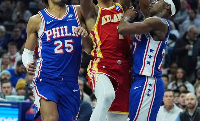 Atlanta Hawks' Jalen Johnson, center, goes up to shoot against Philadelphia 76ers' Dominick Barlow (25) and Vj Edgecombe, right, during the first half of an NBA basketball game Thursday, Feb. 19, 2026, in Philadelphia. (AP Photo/Matt Rourke)