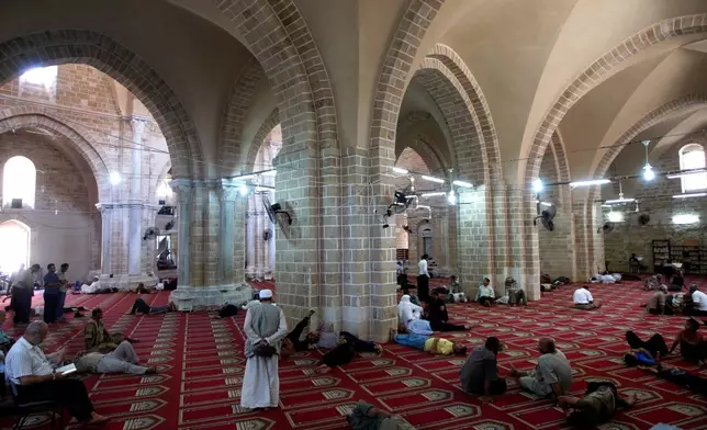 FILE - Palestinian men rest or pray in the Great Omari Mosque in Gaza City during the Muslim holy month of Ramadan before it was damaged by an Israeli strike during the war with Hamas, Tuesday, Aug. 17, 2010. (AP Photo/ Khalil Hamra, File)