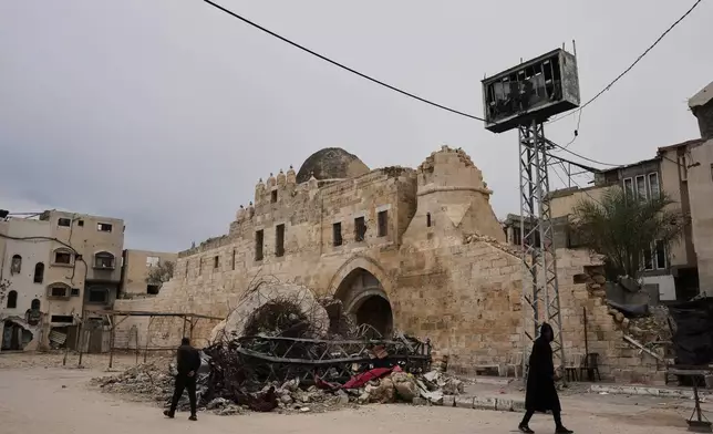 Palestinians walk in front of the Barqouq Castle in Khan Younis, southern Gaza Strip after it was damaged during the Israel-Hamas war Thursday, Jan. 22, 2026. (AP Photo/Abdel Kareem)