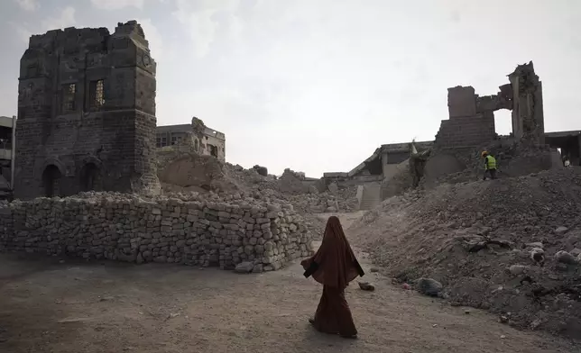 FILE - A Palestinian woman walks past the historic Pasha Palace in Gaza City after an Israeli airstrike badly damaged the building during the war in the Gaza Strip, Thursday, Nov. 13, 2025. (AP Photo/Jehad Alshrafi, File)