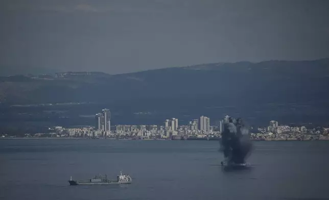 An incoming projectile explodes over the water as Israel issues a nationwide alert following its strikes on Iran, in Haifa Bay, northern Israel, Saturday, Feb. 28, 2026. (AP Photo/Leo Correa)