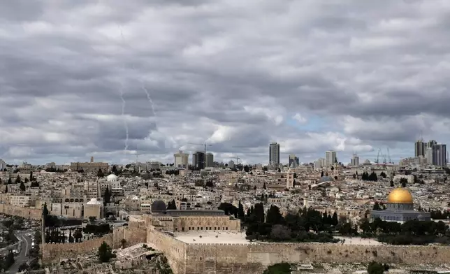 Traces of an air defense missile interception are seen, left, over Jerusalem's Old City, Saturday, Feb. 28, 2026. (AP Photo/Mahmoud Illean)