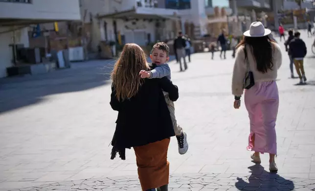 People rush to take shelter as warning sirens sound following missile fired towards Israel, in Tel Aviv, Israel, Saturday, Feb. 28, 2026. (AP Photo/Ohad Zwigenberg)