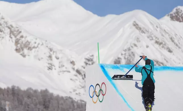 A worker preps a ramp before a freestyle skiing slopestyle training session at the 2026 Winter Olympics, in Livigno, Italy, Thursday, Feb. 5, 2026. (AP Photo/Lindsey Wasson)