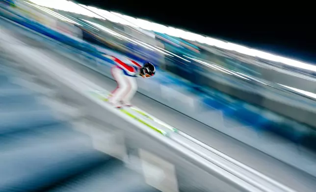 Liu Qi of China goes down the ramp during a ski jumping women's normal hill training session at the 2026 Winter Olympics in Predazzo, Italy, Thursday, Feb. 5, 2026. (AP Photo/Matthias Schrader)