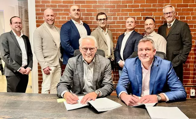 Martin Jacques, COO at Pomerleau, and Eric Desaulniers, President &amp; CEO of NMG, officialize a new collaboration chapter in presence of key team members.