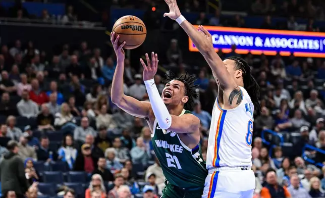 Milwaukee Bucks forward Ousmane Dieng (21) shoots against Oklahoma City Thunder forward Jaylin Williams during the first half of an NBA basketball game Thursday, Feb. 12, 2026, in Oklahoma City. (AP Photo/Gerald Leong)