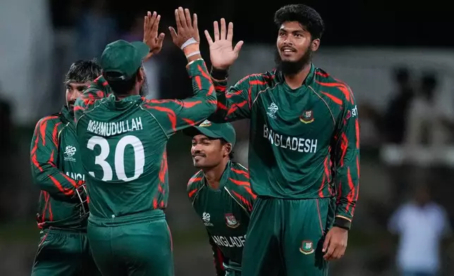 FILE - Bangladesh's Rishad Hossain, right, is congratulated by teammate Mahmudullah after dismissing Australia's Travis Head during the ICC Men's T20 World Cup cricket match between Australia and Bangladesh in North Sound, Antigua and Barbuda, Thursday, June 20, 2024. (AP Photo/Lynne Sladky, File)