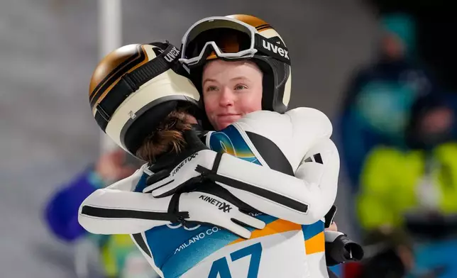 Silver medalist Eirin Maria Kvandal, of Norway, right, hugs gold medalist Anna Odine Stroem, also of Norway, after the ski jumping women's large hill individual at the 2026 Winter Olympics, in Predazzo, Italy, Sunday, Feb. 15, 2026. (AP Photo/Kirsty Wigglesworth)