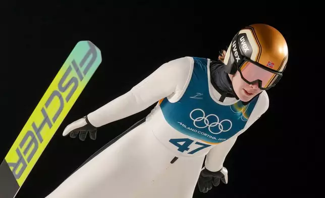 Anna Odine Stroem, of Norway, soars through the air during her first round jump of the ski jumping women's large hill individual at the 2026 Winter Olympics, in Predazzo, Italy, Sunday, Feb. 15, 2026. (AP Photo/Evgeniy Maloletka)