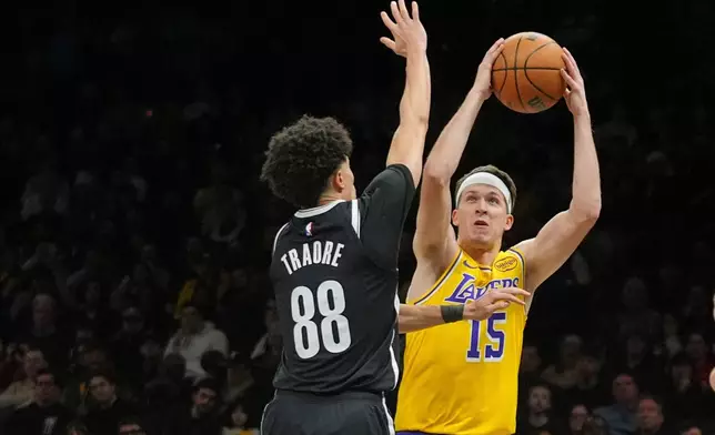 Los Angeles Lakers' Austin Reaves (15) shoots over Brooklyn Nets' Nolan Traore (88) during the first half of an NBA basketball game =Tuesday, Feb. 3, 2026, in New York. (AP Photo/Frank Franklin II)