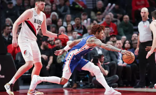 Philadelphia 76ers forward/guard Kelly Oubre Jr. (9) grabs for a loose ball ahead of Portland Trail Blazers center Donovan Clingan (23) during the second half of an NBA basketball game Monday, Feb. 9, 2026, in Portland, Ore. (AP Photo/Amanda Loman)