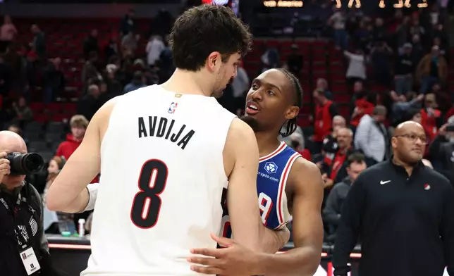 Portland Trail Blazers forward Deni Avdija (8) and Philadelphia 76ers guard Tyrese Maxey (0) hug following an NBA basketball game Monday, Feb. 9, 2026, in Portland, Ore. (AP Photo/Amanda Loman)