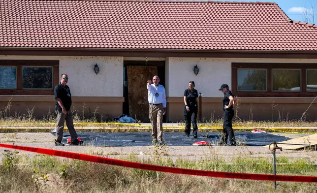 FILE - Fremont County coroner Randy Keller, center, and other authorities survey the area where they plan to put up tents at the Return to Nature Funeral Home where over 100 bodies have been improperly stored, Oct. 7, 2023, in Penrose, Colo. (Parker Seibold/The Gazette via AP, File)