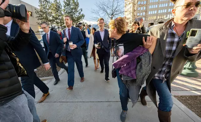 FILE - Chrystina Page, right, holds back Heather De Wolf, as she yells at Jon Hallford, left, the owner of Back to Nature Funeral Home, as he leaves with his lawyers following a preliminary hearing, Feb. 8, 2024, outside the El Paso County Judicial Building, in Colorado Springs, Colo. (Christian Murdock/The Gazette via AP, File)
