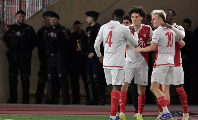 Monaco's Folarin Balogun celebrates with teammates after scoring his side's second goal during the first-leg of the Champions League playoff soccer match between Monaco and Paris Saint-Germain in Monaco, Tuesday, Feb. 17, 2026. (AP Photo/Philippe Magoni)