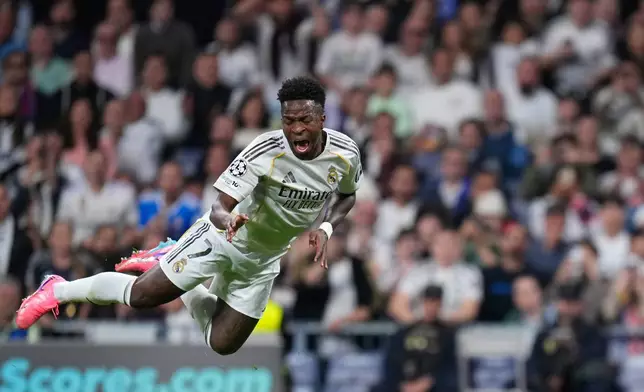 Real Madrid's Vinicius Junior falls during the second leg of the Champions League playoff soccer match between Real Madrid and Benfica in Madrid, Spain, Wednesday, Feb. 25, 2026. (AP Photo/Manu Fernandez)