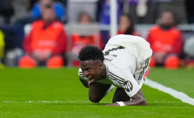 Real Madrid's Vinicius Junior reacts after sustaining an injury during the second leg of the Champions League playoff soccer match between Real Madrid and Benfica in Madrid, Spain, Wednesday, Feb. 25, 2026. (AP Photo/Manu Fernandez)
