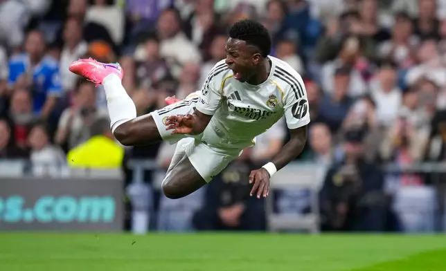 Real Madrid's Vinicius Junior falls during the second leg of the Champions League playoff soccer match between Real Madrid and Benfica in Madrid, Spain, Wednesday, Feb. 25, 2026. (AP Photo/Manu Fernandez)