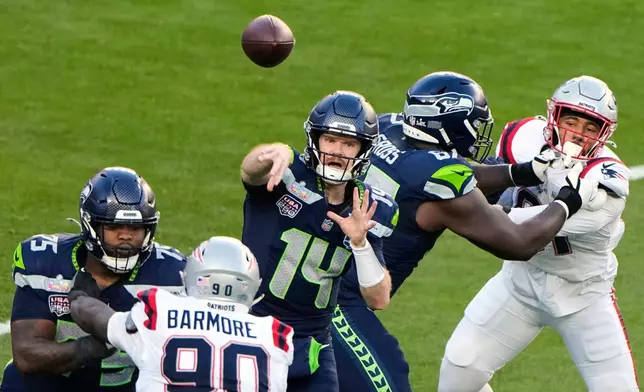 Seattle Seahawks quarterback Sam Darnold (14) throws a pass under pressure from New England Patriots defensive tackle Christian Barmore (90) during the first half of the NFL Super Bowl 60 football game, Sunday, Feb. 8, 2026, in Santa Clara, Calif. (AP Photo/Charlie Riedel)