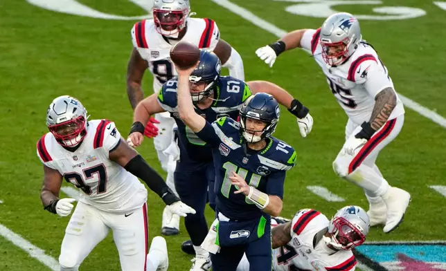 Seattle Seahawks quarterback Sam Darnold (14) throws a pass under pressure from New England Patriots defensive end Milton Williams (97) during the first half of the NFL Super Bowl 60 football game, Sunday, Feb. 8, 2026, in Santa Clara, Calif. (AP Photo/Charlie Riedel)