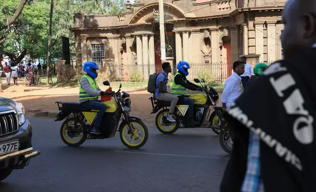 People ride electric motorcycles in Nairobi, Kenya, Thursday, Jan. 29, 2026. (AP Photo/Andrew Kasuku)