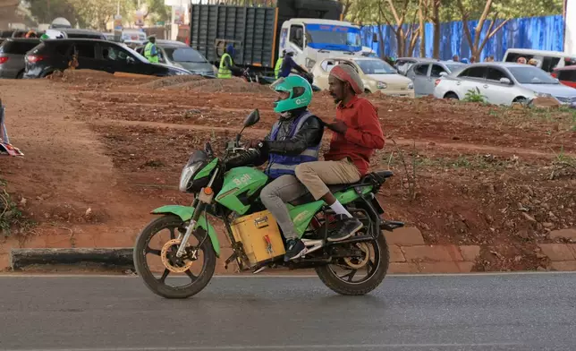 Men ride an electric motorcycle in Nairobi, Kenya, Thursday, Jan. 29, 2026. (AP Photo/Andrew Kasuku)