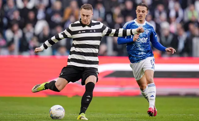 Juventus' Teun Koopmeiners, left, fights for the ball with Como's Maxence Caqueret during the Italian Serie A soccer match between Juventus and Como in Turin, Italy, Saturday, Feb. 21, 2026. (Marco Alpozzi/dpa via AP)