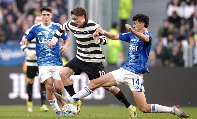Juventus' Kenan Yildiz fights for the ball with Como's Jacobo Ramon, right, during the Italian Serie A soccer match between Juventus and Como in Turin, Italy, Saturday, Feb. 21, 2026. (Marco Alpozzi/LaPresse via AP)